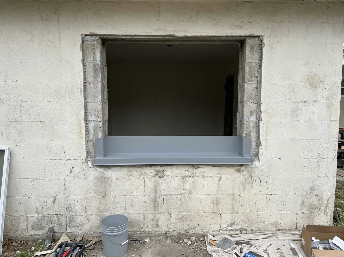 Window opening with the old window removed showing a sill pan flashing in place